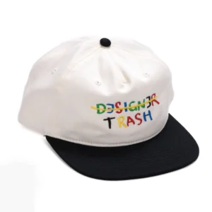 White baseball cap with a black curved brim and colorful 'DESIGNER TRASH' embroidery on the front panel.