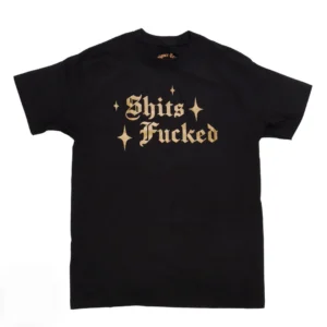Black T-shirt laid flat with gold Gothic text reading 'Shits Fucked' and star accents on the front.