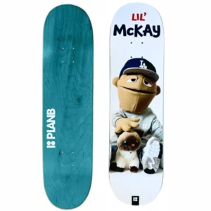 Two skateboard decks side by side: left teal Plan B with wood grain, right white deck featuring Lil' McKay character in an LA cap with a plush dog